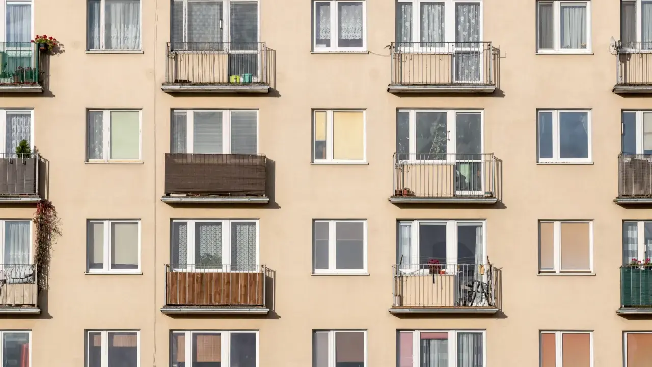 Façade d'immeuble avec de nombreux balcons et fenêtres, offrant un aperçu de la vie quotidienne et du **logement décent**.