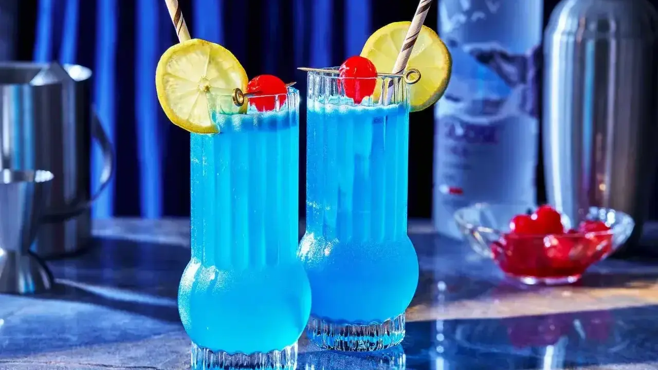 Dwa orzeźwiające drinki Blue Lagoon z cytryną i wiśnią, gotowe do podania.