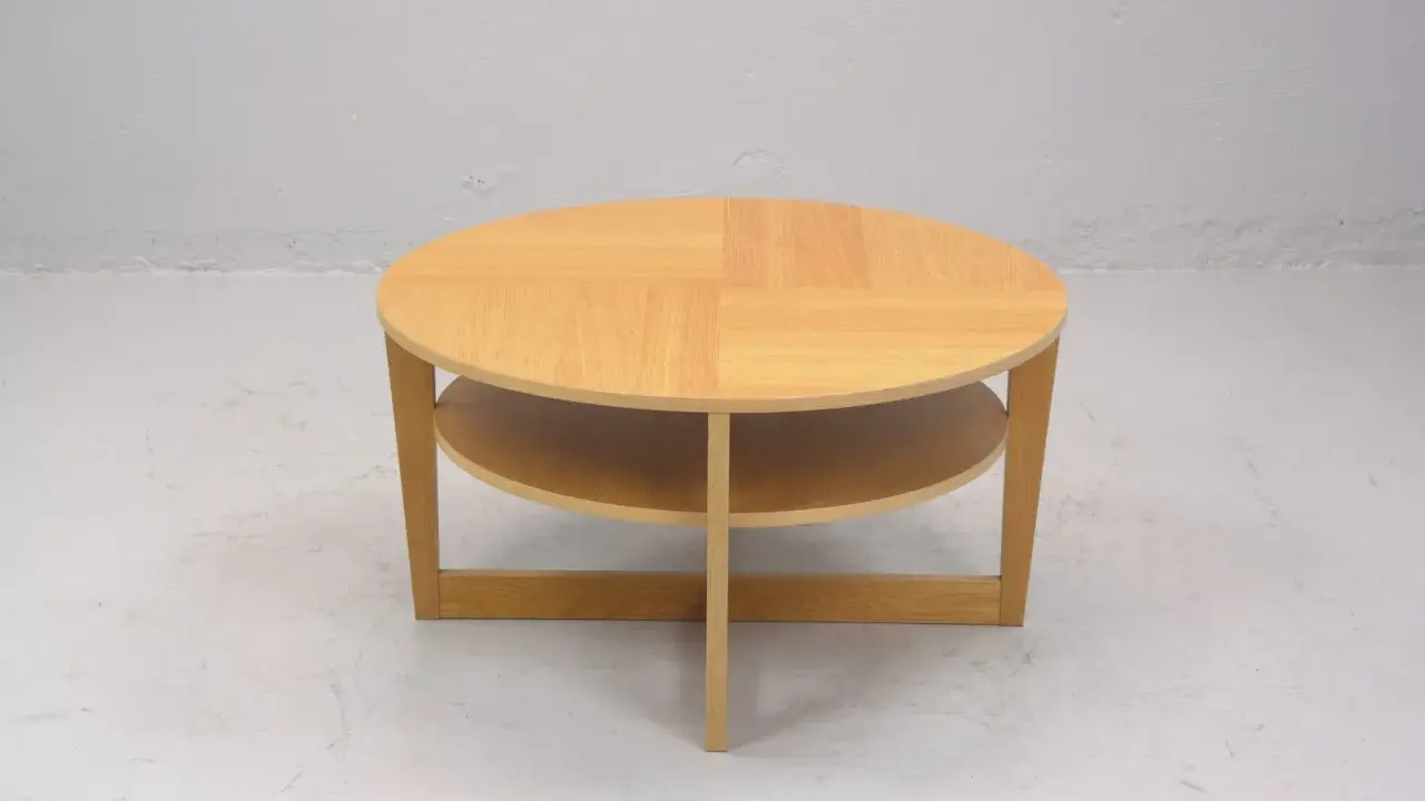 Rundt, ljust träbord med två hyllplan, en klassisk IKEA VEJMON EK. Perfekt för vardagsrummet.