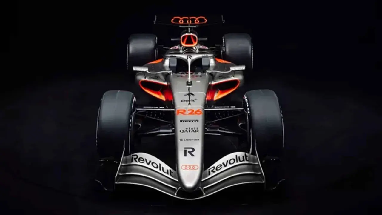 El coche de audi f1, plateado con detalles naranjas y negros, listo para la competición.