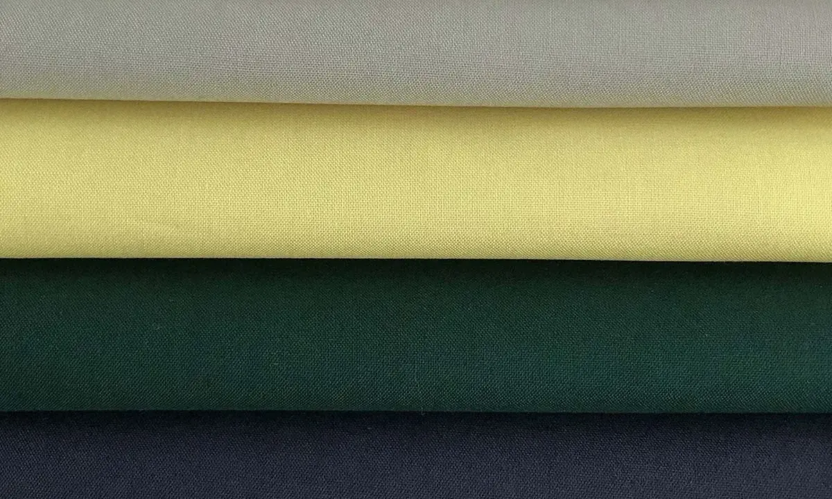 Stacked swatches of poplin fabric in white, light grey, yellow, dark green, and navy blue.