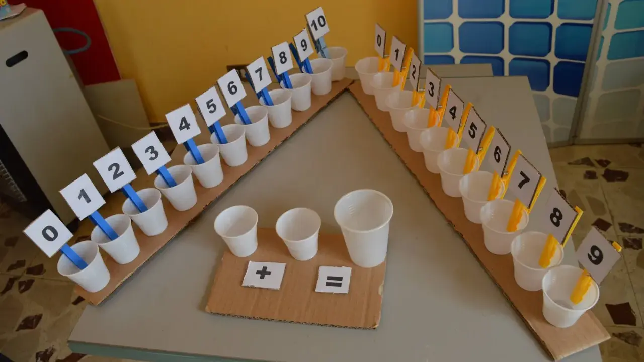 Una linea dei numeri da costruire con bicchierini e cartellini numerati da 0 a 10. Simboli matematici per esercizi.