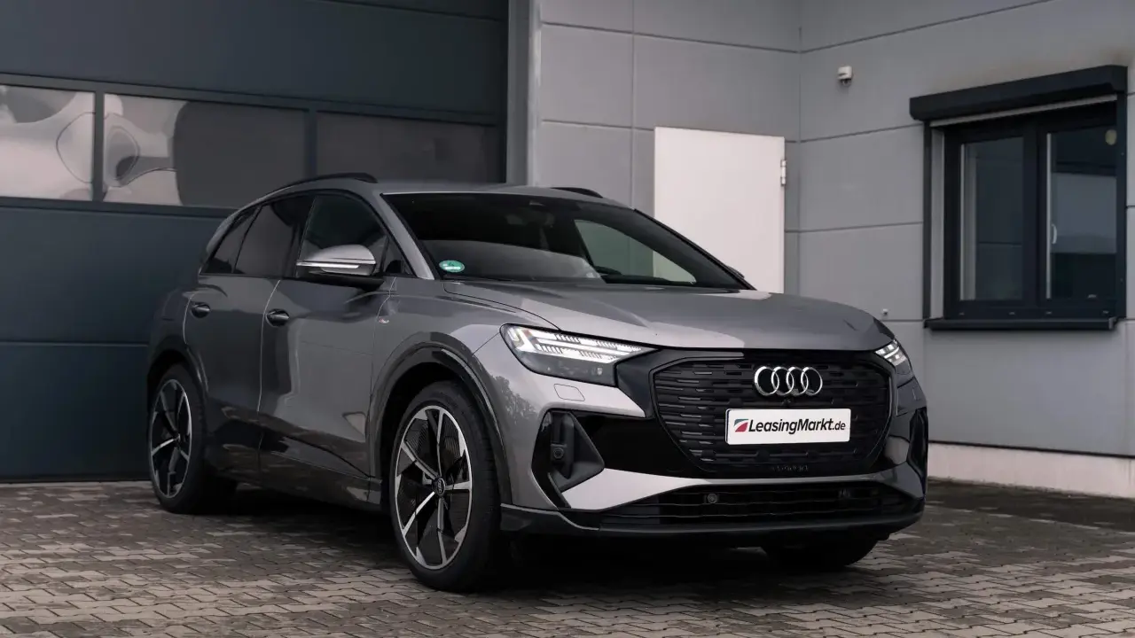 Grauer Audi q4 e tron steht vor einer Garage.