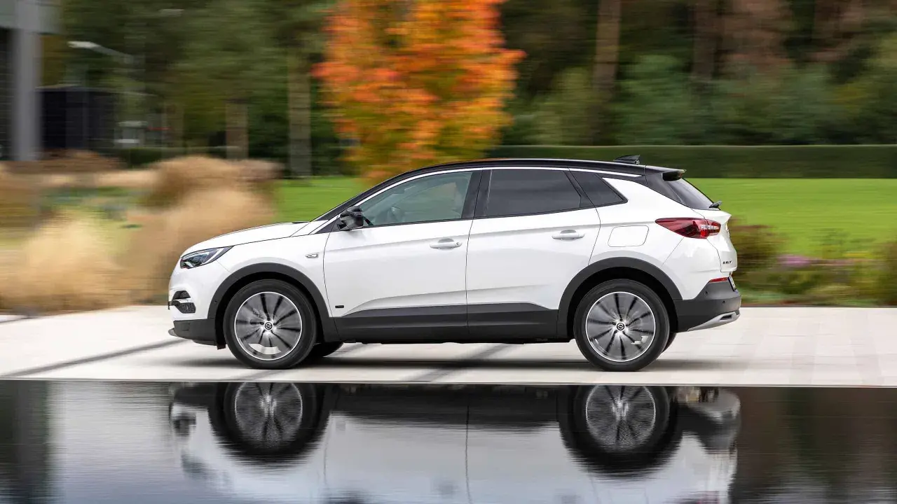Biały Opel Grandland w ruchu, z refleksami na wodzie. Sprawdź aktualną opel grandland cena i wybierz swój wymarzony SUV.