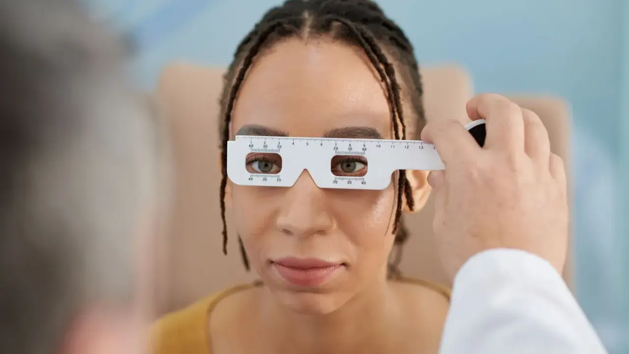 Badanie wzroku u optometrysty. Pacjentka ma na nosie przyrząd do pomiaru rozstawu źrenic. Czas oczekiwania na okulary zależy od wielu czynników.