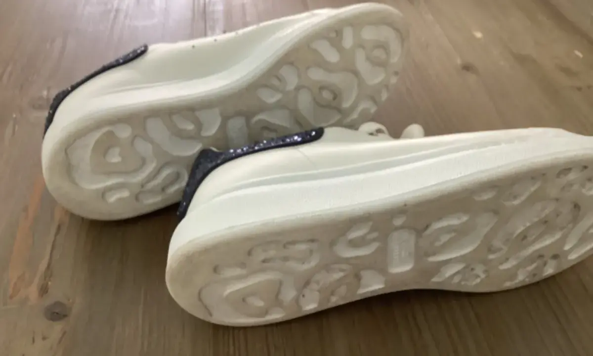 Białe sneakersy Alexander McQueen z granatowymi brokatowymi wstawkami. Zwróć uwagę na charakterystyczną podeszwę, by jak rozpoznać oryginalne buty Alexander McQueen.