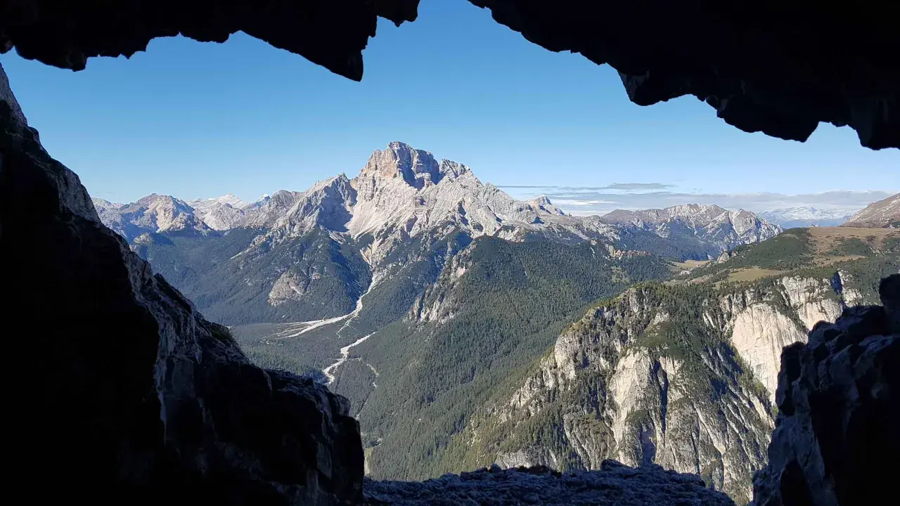 Vista mozzafiato dal **Monte Piana**, con valli profonde, foreste rigogliose e cime maestose sotto un cielo azzurro.