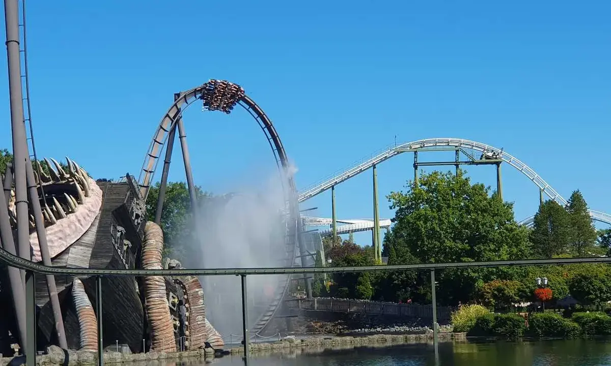 Achterbahn im Heide Park mit Wassereffekt und einem großen Holzmonster.