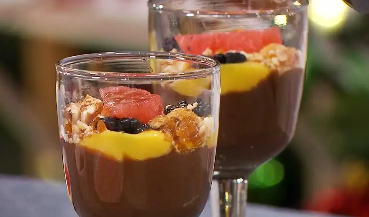 Två glas med chokladpudding, toppad med mango, bär, nötter och grapefrukt. Ett perfekt chokladpudding recept för fest!