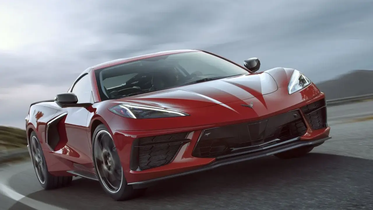 Czerwony Chevrolet Corvette C8 pędzi po drodze, jego sportowy design podkreślony przez dynamiczne linie i agresywny przód.