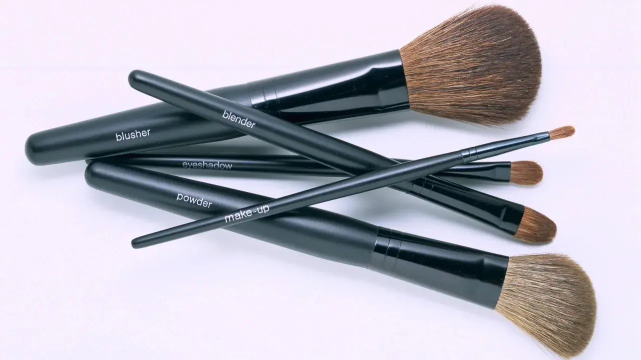 Un conjunto de brochas de maquillaje negras etiquetadas como "blusher", "blender", "eyeshadow", "powder" y "make-up". Aprende como limpiar brochas de maquillaje para mantenerlas en perfecto estado.