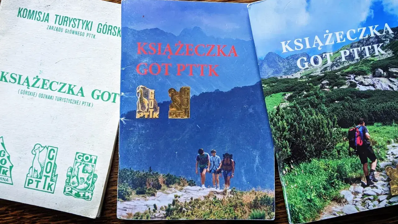 Trzy książeczki GOT PTTK z odznakami. Jedna biała z zielonymi symbolami, dwie z górskimi krajobrazami.