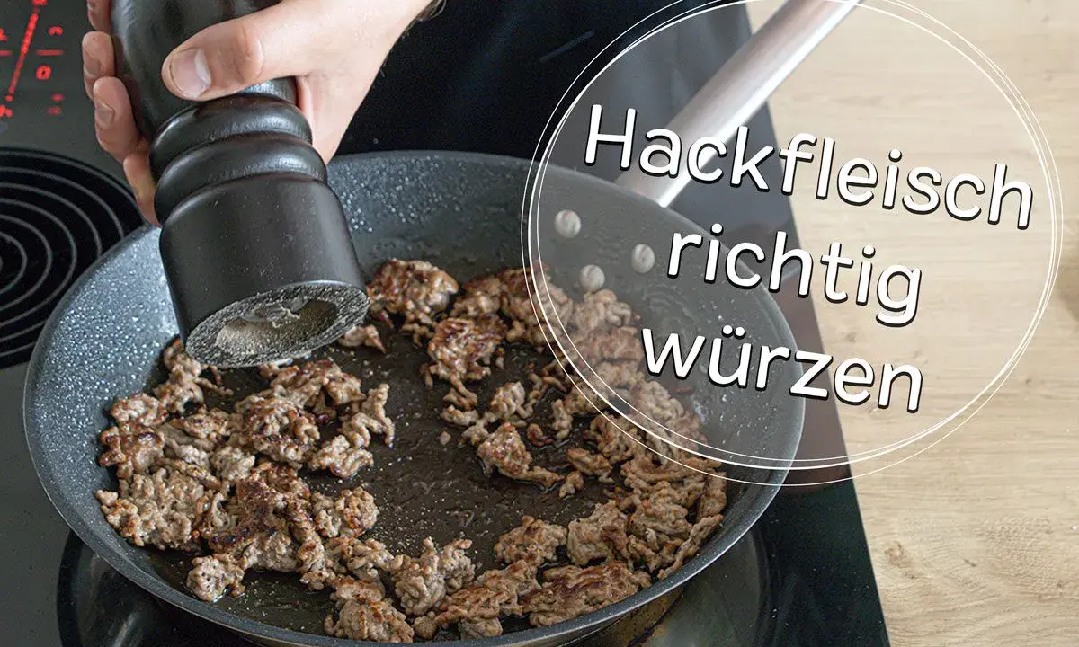 Hand würzt Hackfleisch in Pfanne. Die Frage "wieviel Salz auf ein Kilo Hackfleisch" wird hier visuell beantwortet: richtig würzen!