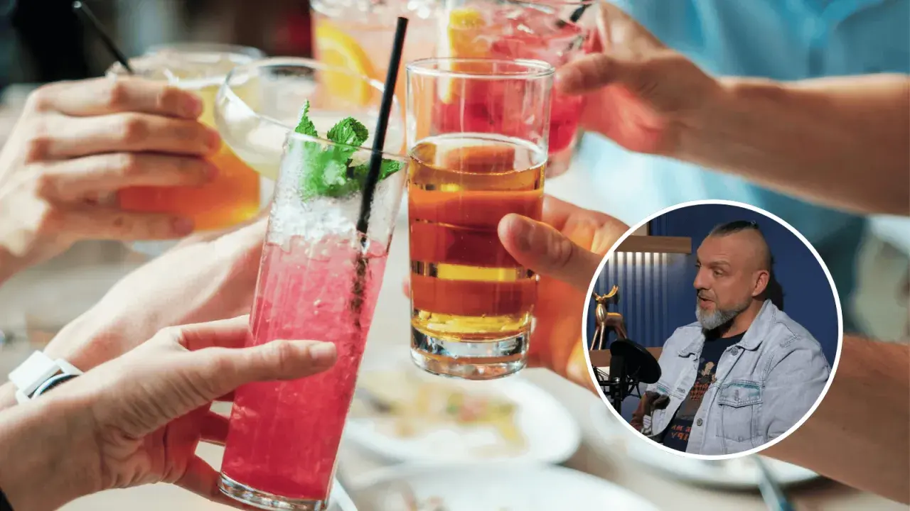 Ludzie wznoszą toasty kolorowymi drinkami. W tle mężczyzna dyskutuje, czy alkohol to narkotyk.
