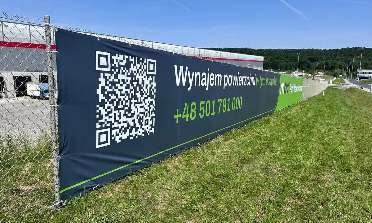 Baner informuje: "Wynajem powierzchni w tym budynku". Jak zrobic baner? Skanuj QR kod lub dzwoń +48 501 791 000.