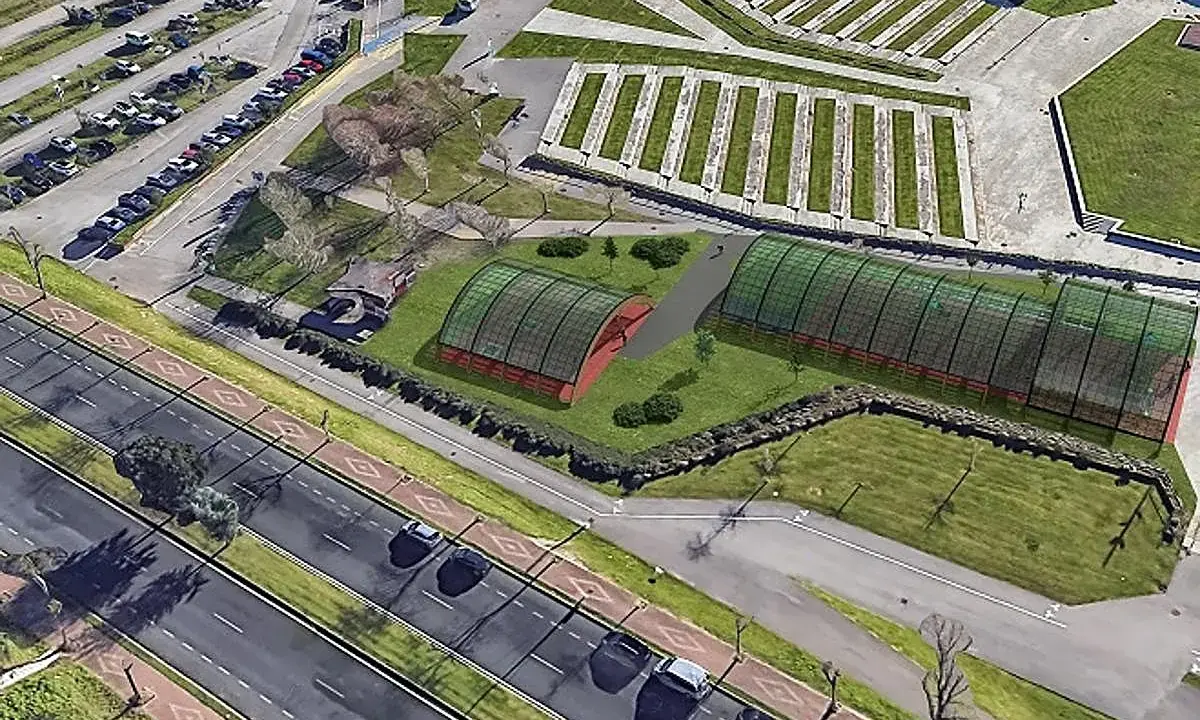Vista aérea de un complejo deportivo con dos invernaderos verdes y una zona de aparcamiento. El **parque de las llamas** se extiende hasta la carretera.