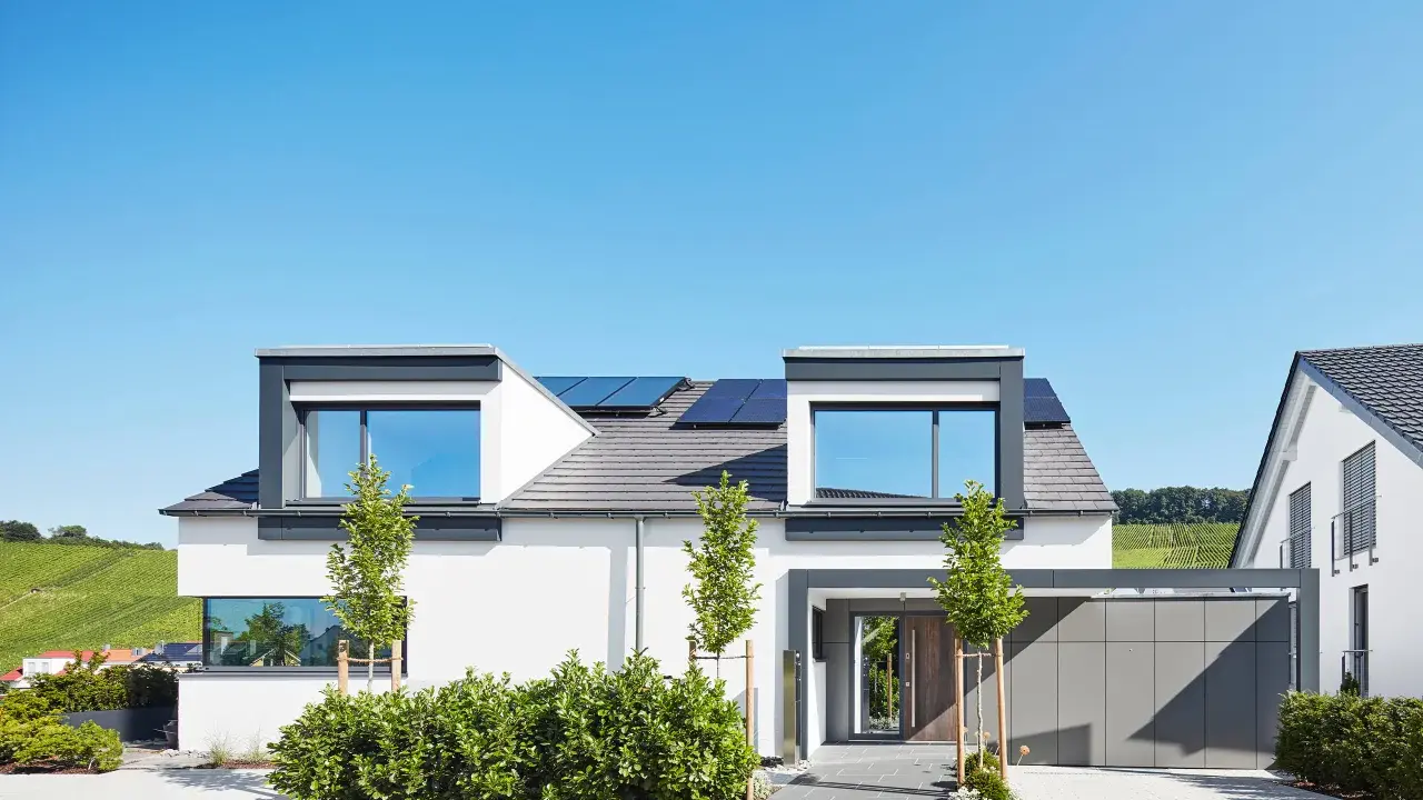 Modernes Einfamilienhaus mit Solaranlage, gestaltet von einem erfahrenen hausbau architekt. Klare Linien und viel Licht prägen das Bild.