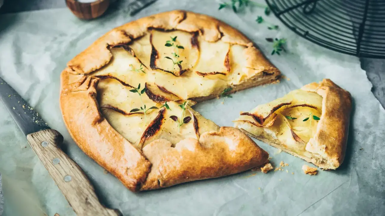Galette aux pommes, recette de maman, dorée et garnie de fines tranches de pommes, prête à être dégustée.