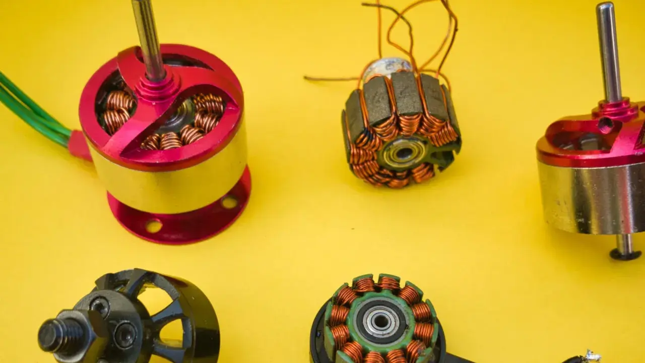 Vergleich von brushed und brushless Motoren: zwei komplette Motoren und zwei freigelegte Spulen mit Kupferwicklungen auf gelbem Hintergrund.