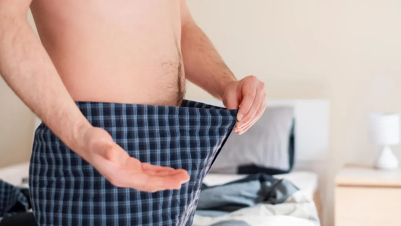 Mann mit Karo-Boxershorts, der sich fragt, ob Rauchstopp Potenz Erfahrungen positiv beeinflusst.
