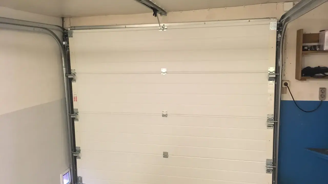 Monterad verisure magnetkontakt på garageporten. Enkel installation för ökad säkerhet.