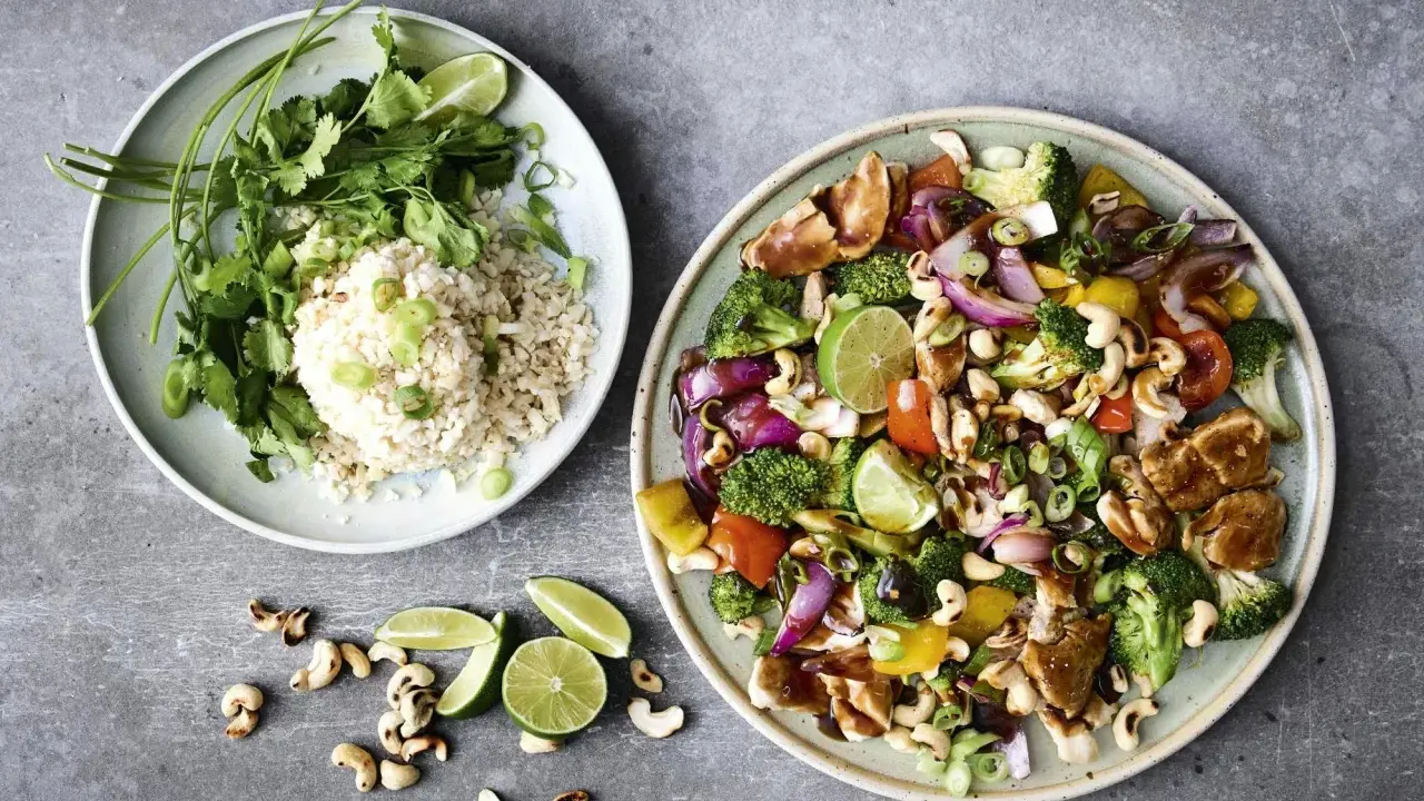Enkel lunch med kyckling, grönsaker, cashewnötter och ris. Serveras med lime och koriander.
