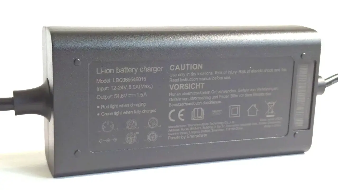 Graues Netzteil mit der Aufschrift "Output: 54.6V 1.5A". Dieses Netzteil 12V 5A ist für Li-ion Akkus.