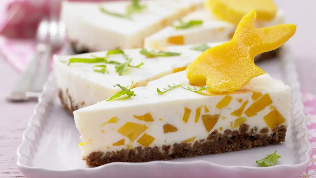 Süße Ostertorten Rezepte: Cremiger Kuchen mit Mango-Stückchen und Osterhasen-Deko aus Mango.