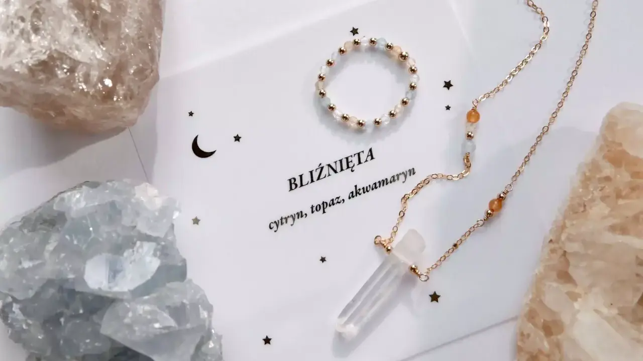 Delikatna biżuteria z kamieniami, w tym akwamaryn, otoczona surowymi kryształami.