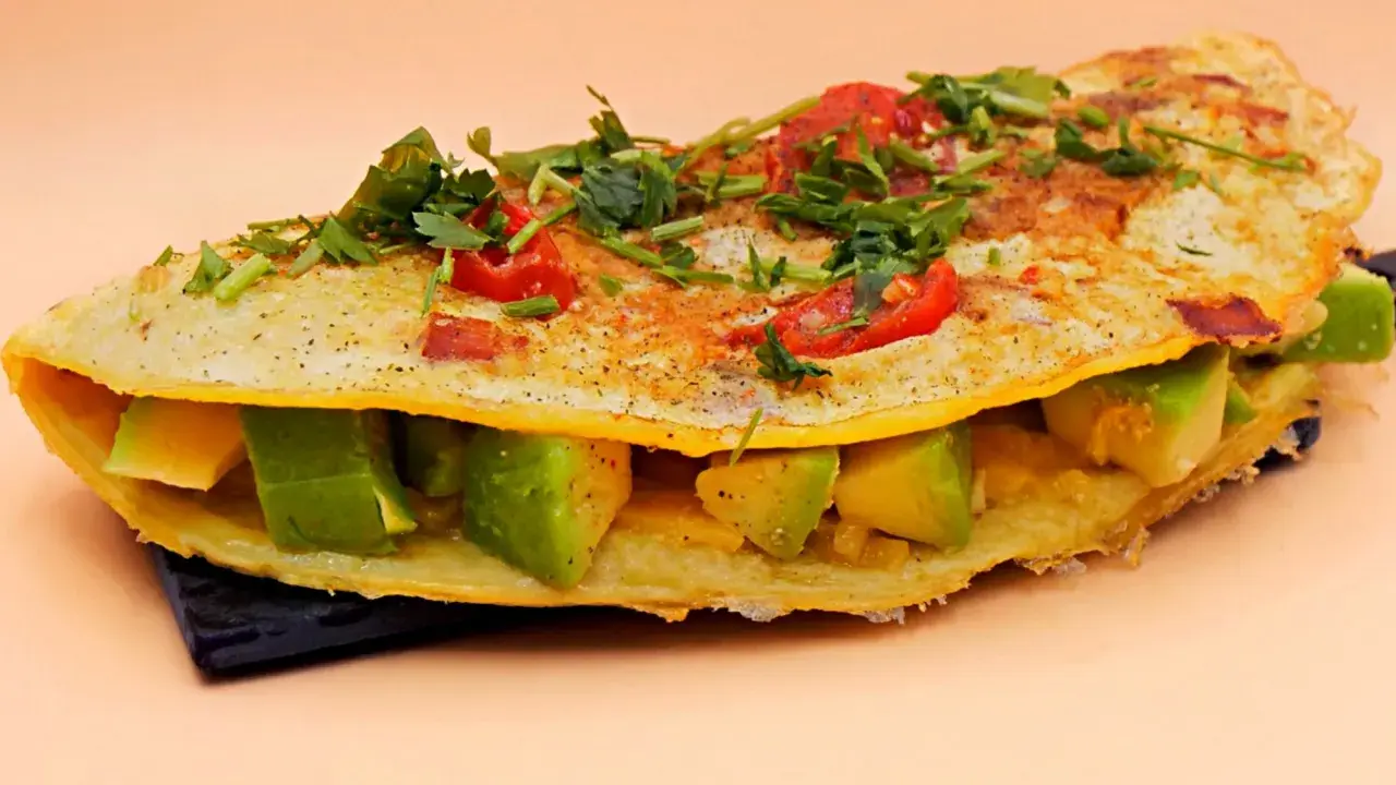 Omlet z awokado, pomidorkami i ziołami, pyszne i zdrowe śniadanie.