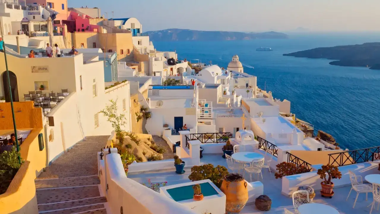 Piękne białe domy Santorini z widokiem na błękitne morze. Idealna pogoda na krecie, by podziwiać krajobraz.