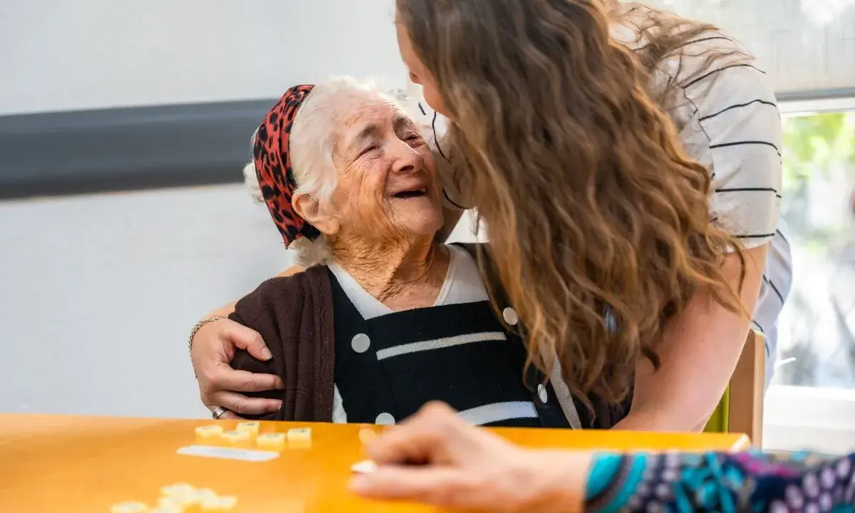 Giovane abbraccia anziana sorridente, un momento di affetto che contrasta il timore del decadimento cognitivo improvviso.