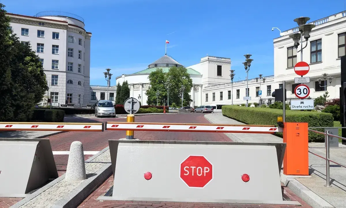 Przed Sejmem RP, gdzie dyskutuje się, ile wynosi dieta poselska, szlaban i znak STOP.