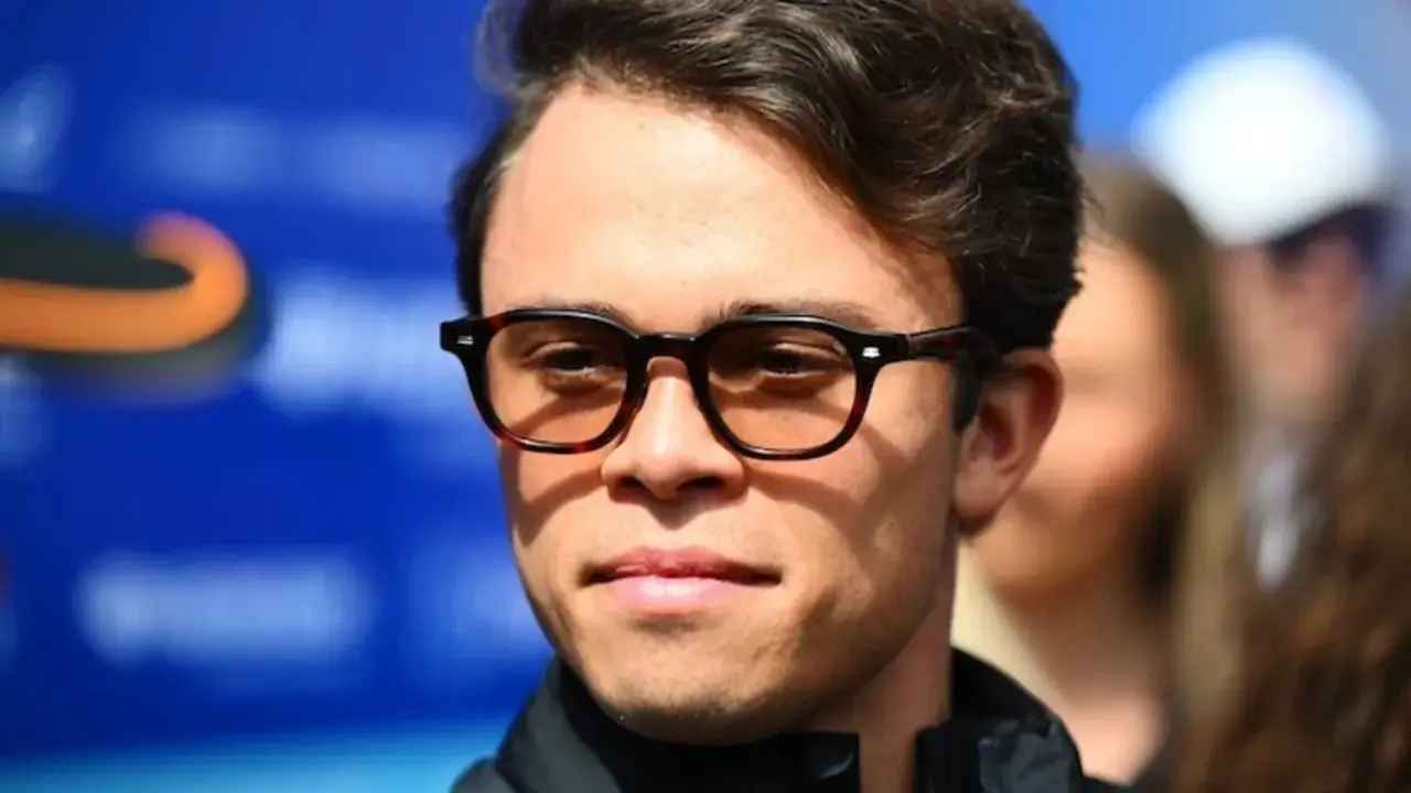 Nyck de Vries, mit seiner charakteristischen Brille, blickt nachdenklich in die Kamera. Hinter ihm verschwimmt eine blaue Wand.