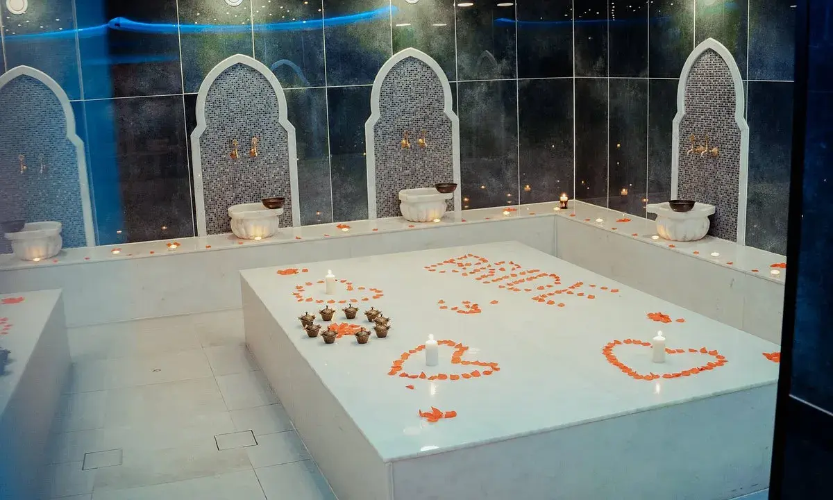 Ett romantiskt **norrsken hammam** med rosenblad och ljus. En lyxig upplevelse väntar.