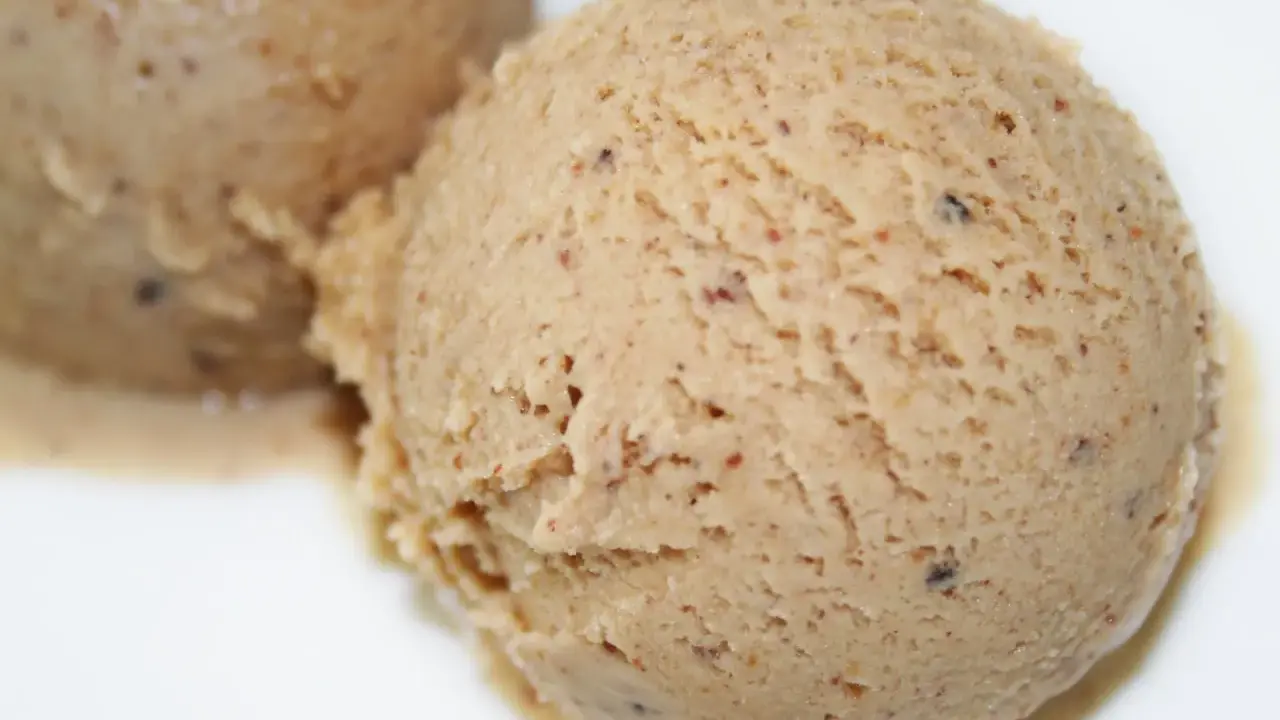 Deux boules de glace praliné, une recette gourmande et onctueuse, parsemée de petits éclats croquants.