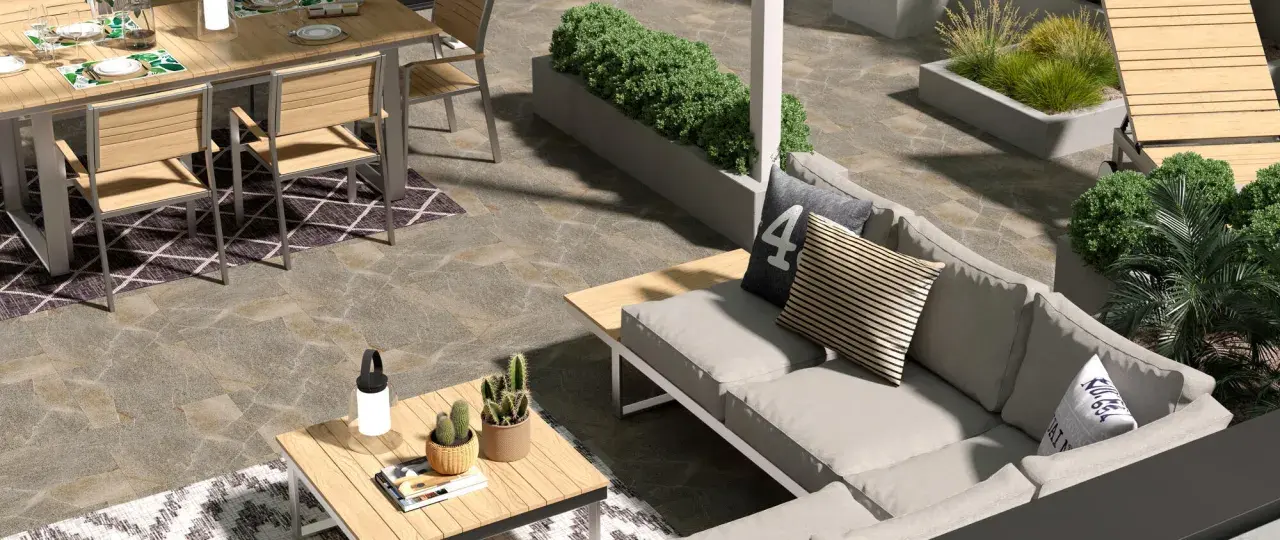 Un elegante giardino pavimentato moderno con divano, tavolo da pranzo e piante.