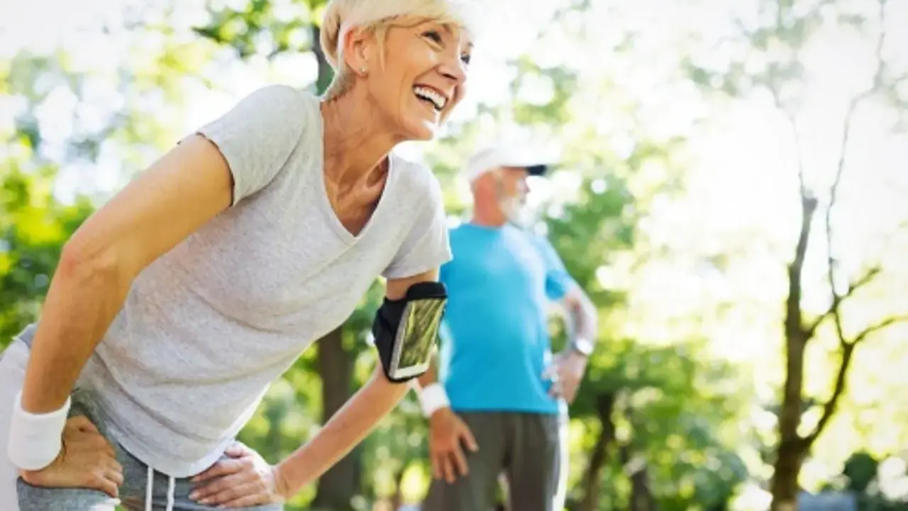 Glückliche Frau und Mann beim Joggen im Alter im Park. Sie genießen die Natur und die Bewegung.