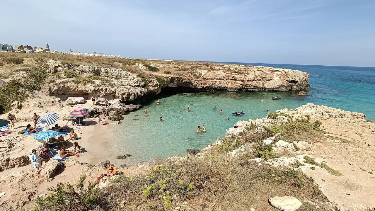 Una splendida giornata alla spiaggia di Porto Verde, con bagnanti che si godono il sole e le acque cristalline.