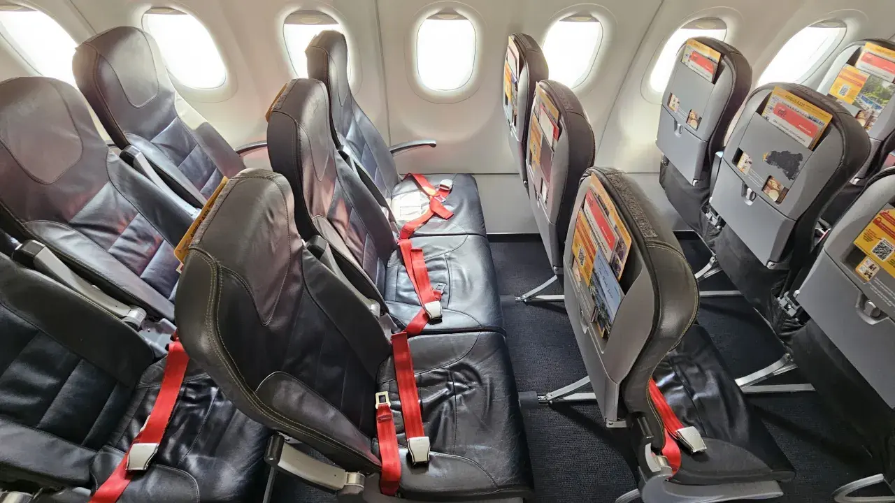 Flygplanssäten med röda säkerhetsbälten. Titta på Pegasus bagageregler innan du packar för din resa.