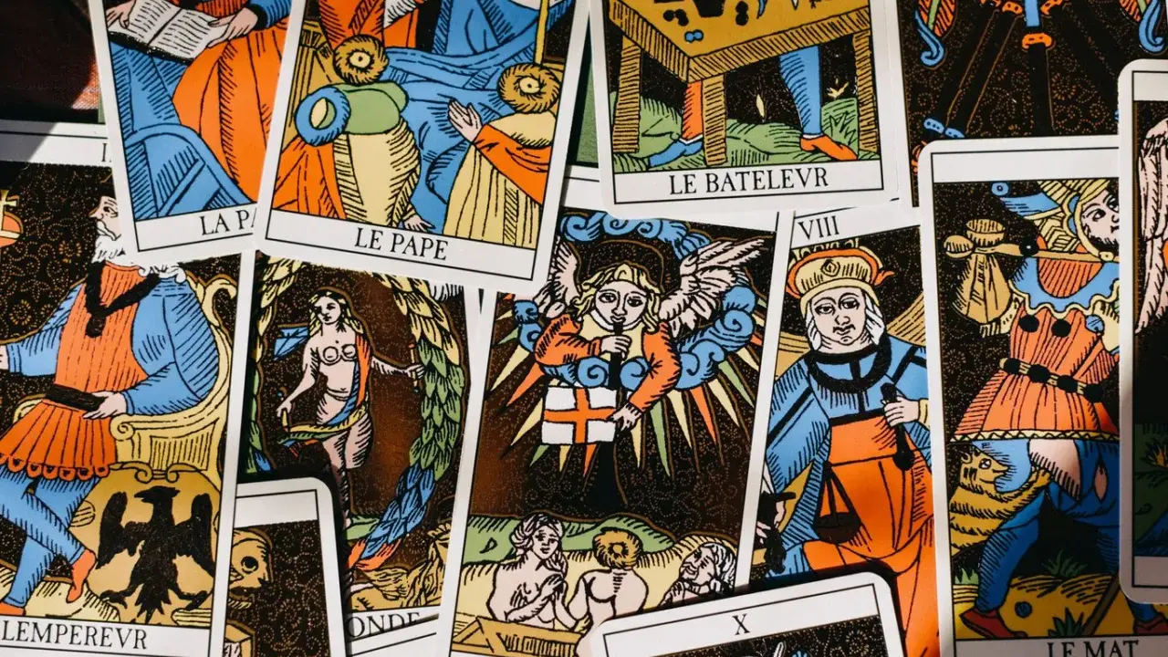 Rozłożone karty tarota, w tym "Le Pape" i "Le Bateleur", sugerują pytania: "tarot co on do mnie czuje?".