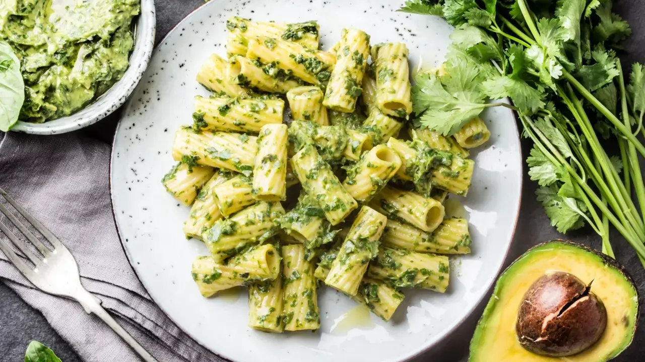 Pyszny makaron z pesto, podany z awokado i świeżymi ziołami. Idealny na szybki obiad.