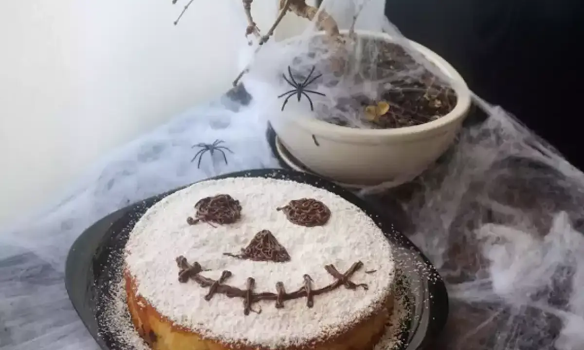 Tarta de Halloween para niños con cara de calabaza decorada con azúcar glas y chocolate. ¡Perfecta para una fiesta espeluznante!