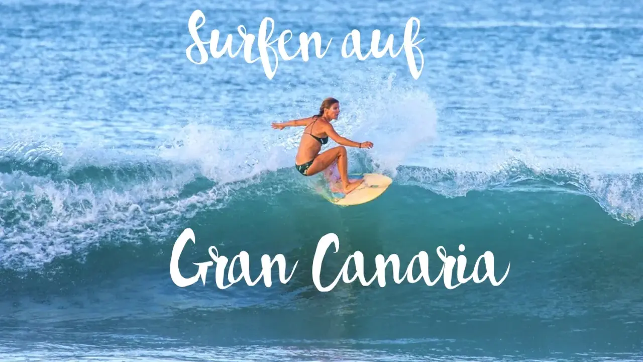 Surfen auf Gran Canaria: Eine Frau surft auf einer Welle, umgeben von Gischt.