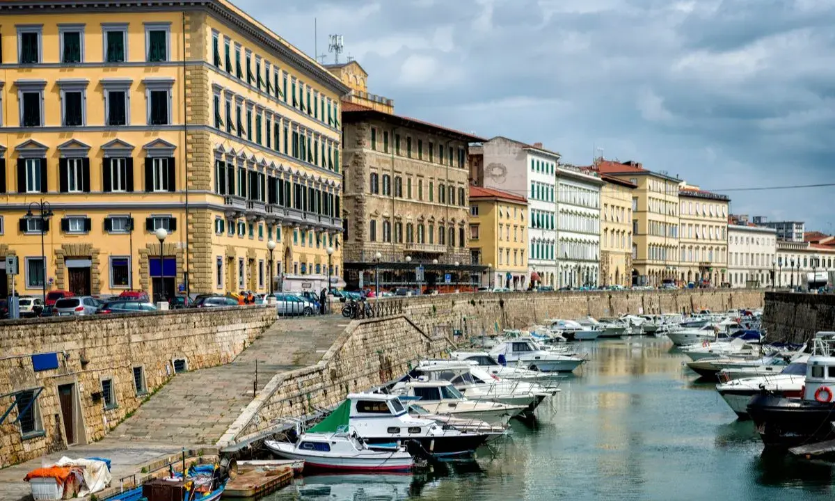 Edifici storici e barche ormeggiate lungo il canale del **terminal crociere Livorno**.