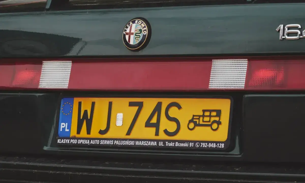 Zielona Alfa Romeo z żółtą rejestracją WJ-74S. Na tablicy widnieje symbol starego samochodu.
