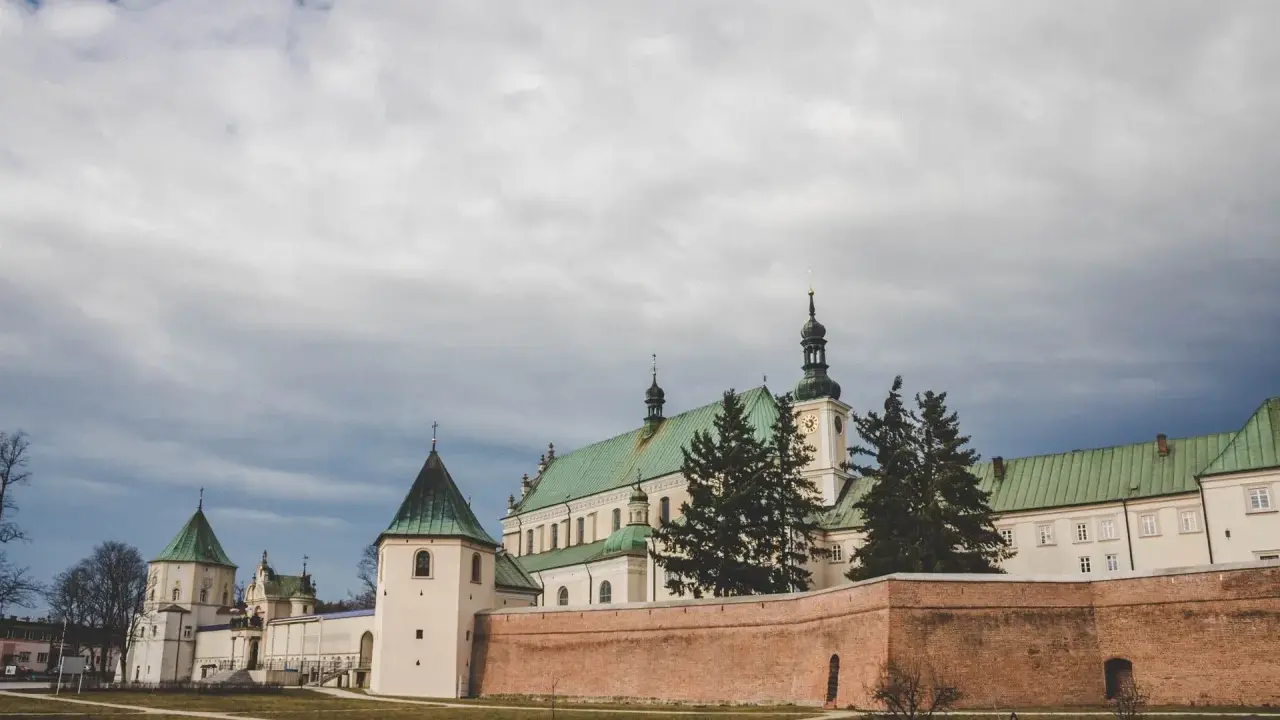 Klasztor Bernardynów w Leżajsku, jedna z głównych atrakcji miasta, z zielonymi dachami i ceglanym murem.