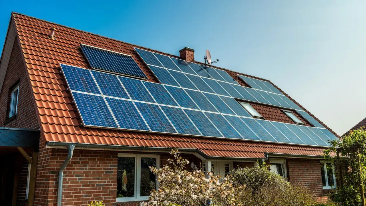 Ett tegelhus med solpaneler på taket, en del av solenergi historia.