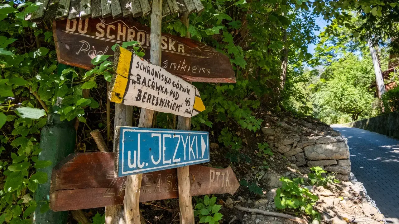 Drewniane drogowskazy wskazują drogę do schroniska górskiego Bacówka pod Beresnikiem. Sprawdź cennik i wybierz szlak!