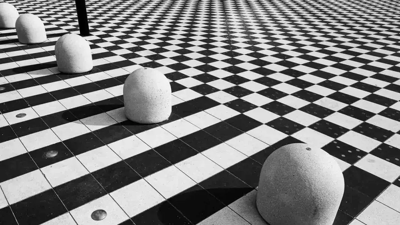Massi ovali su pavimento a scacchi, un gioco di prospettiva e ombre. #streetphotography